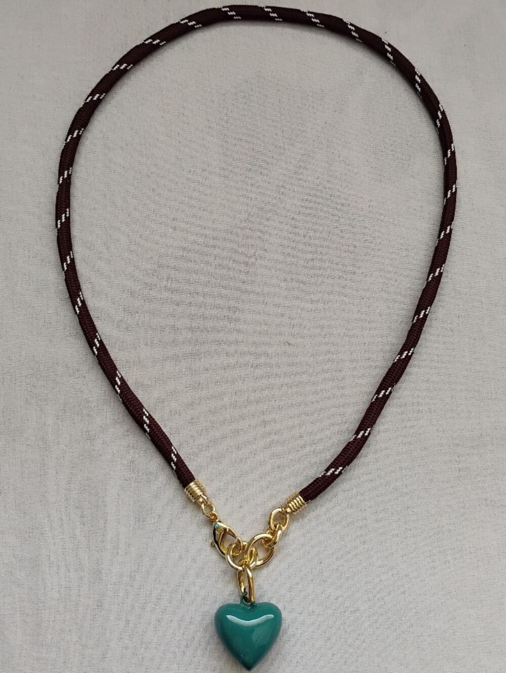 Roxanne Assoulin Brown Cord Necklace with Teal Heart Pendant and Gold Hardware